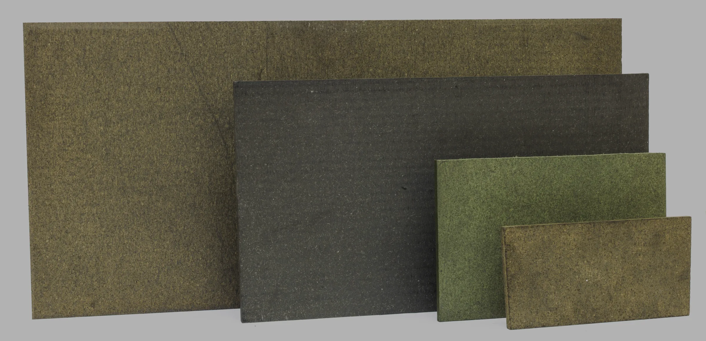 Four flat sheets of friction material in different sizes and colours